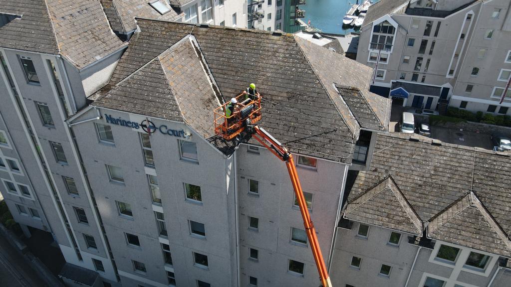 Roof cleaning via cherry picker